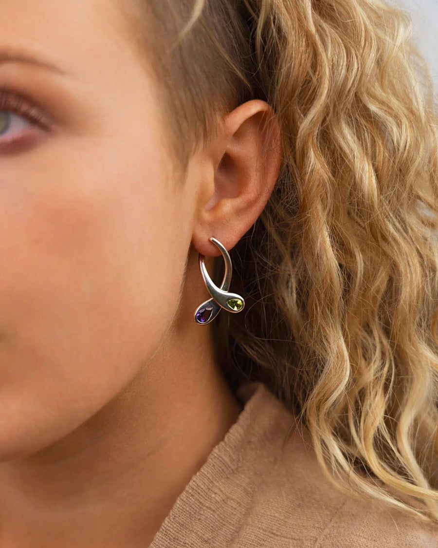 Silver drop earrings with teardrop peridot and amethyst gemstones on ear, organic design