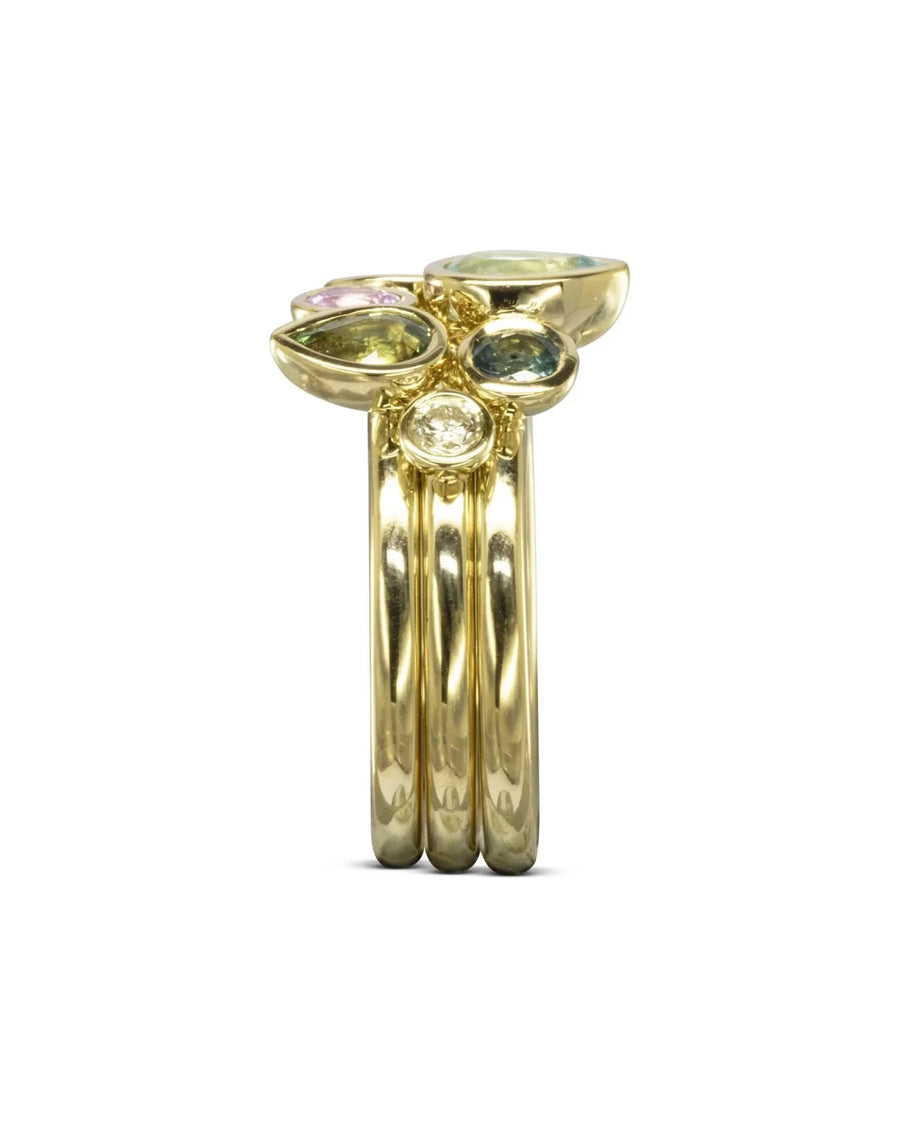 Gold stacking ring set with multi-coloured aquamarine and sapphire pear gemstones.