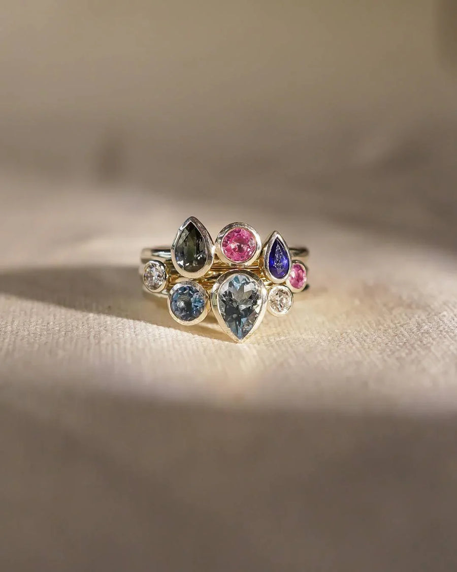 9ct white gold stacking rings with multi-coloured aquamarine and sapphire pear and round gemstones.