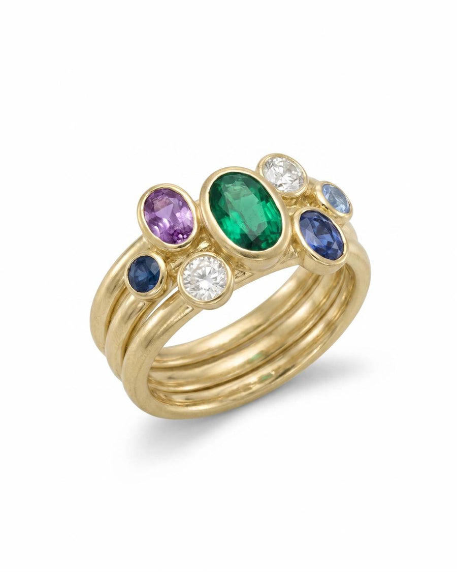 Gold stacking rings with multi-coloured oval sapphires, emerald, and diamonds.
