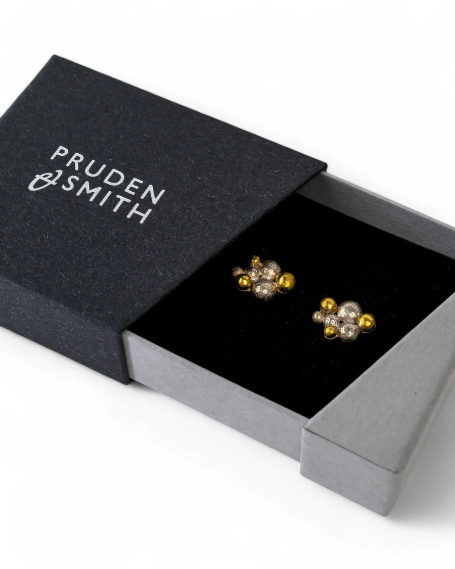 Gold and silver multi nugget stud earrings in a black gift box.