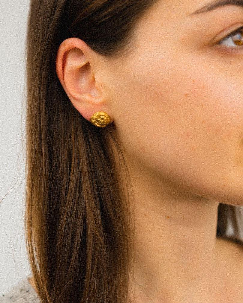 9ct yellow gold nugget stud earring on a woman's ear.