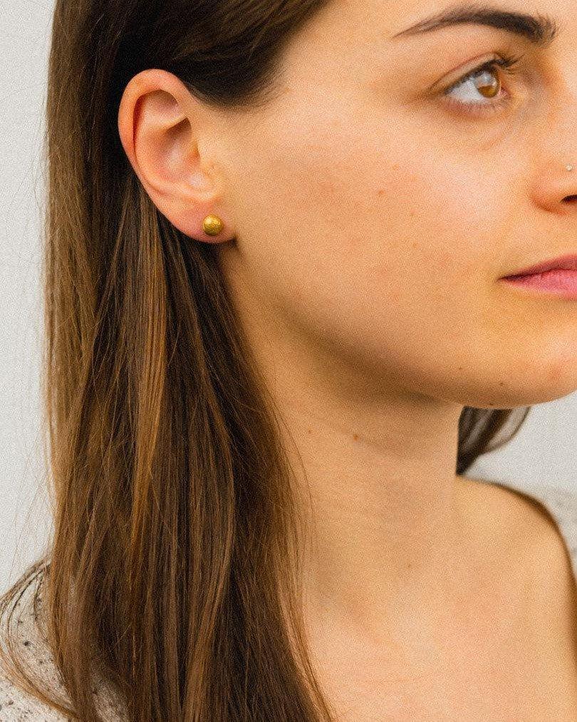 9ct yellow gold nugget stud earring on a woman's ear.