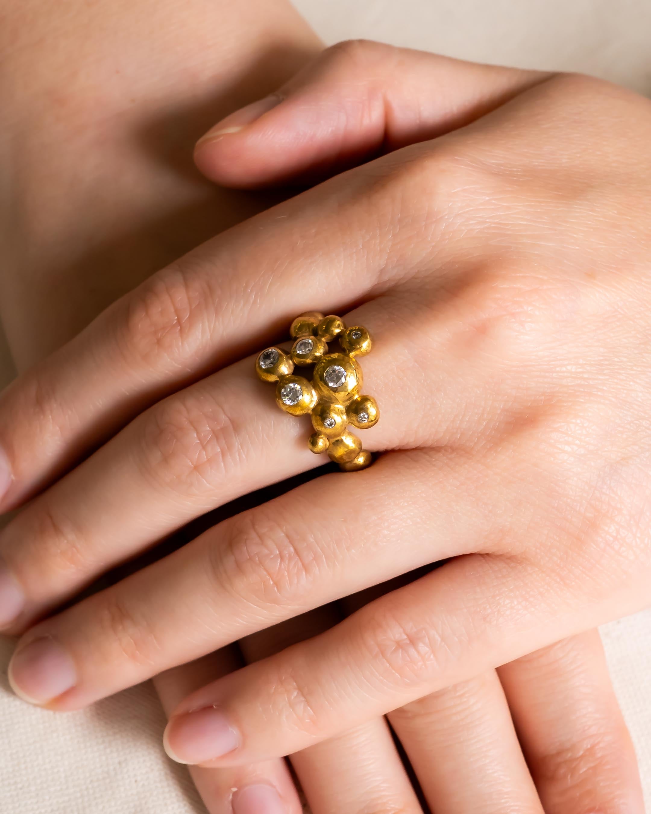 Gold nugget diamond cluster ring on a hand.
