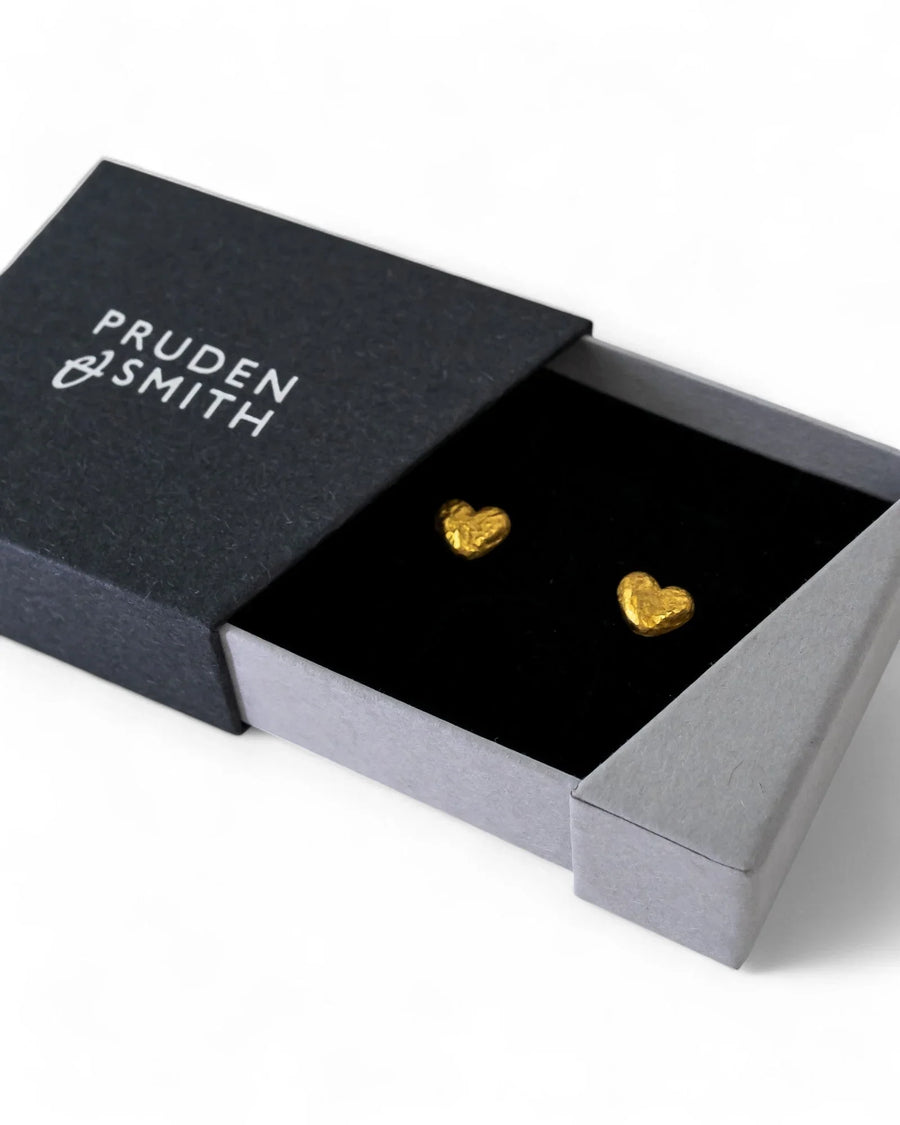 Nugget gold heart stud earrings in a black gift box.