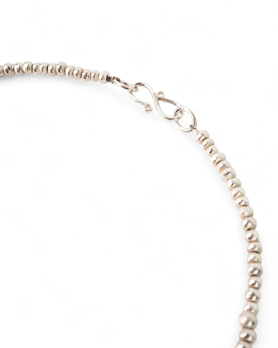 Textured silver nugget necklace with beaded design and S-hook clasp on white background