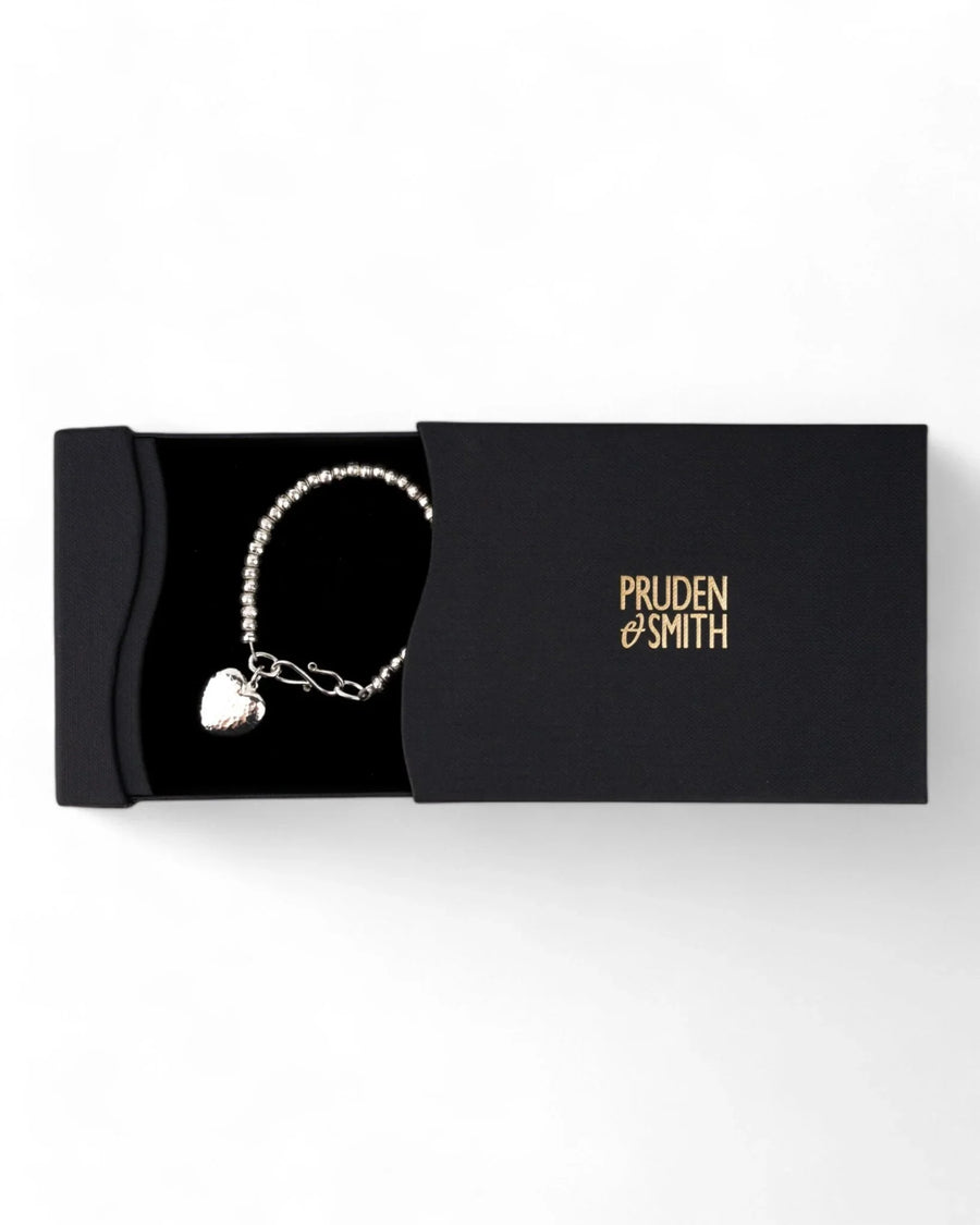 Hammered silver heart charm bracelet with beaded chain in a black gift box