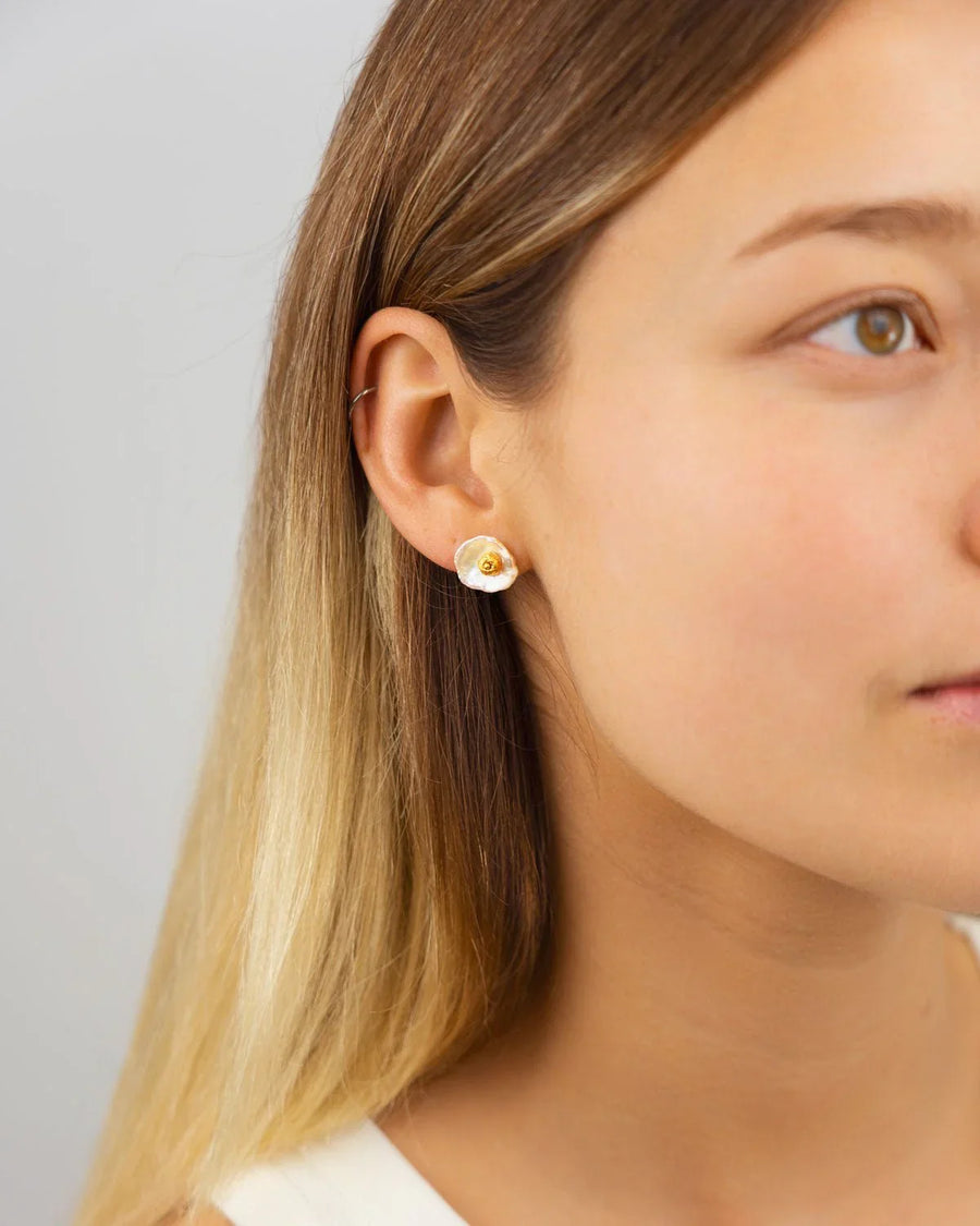 Gold and white nugget keshi pearl stud earring on a woman's ear.