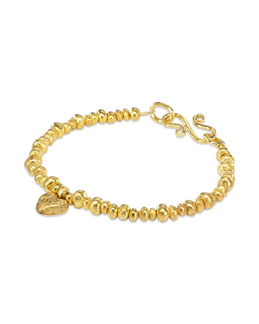 Handmade gold nugget bracelet with textured heart charm and organic beads on white background