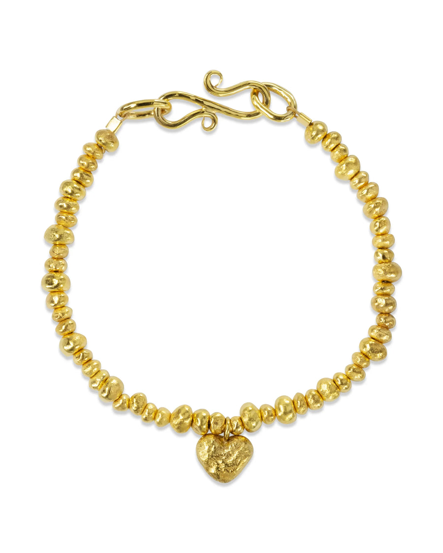Handmade gold nugget bracelet with heart charm and organic shapes on white background