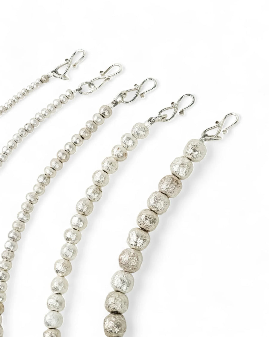 Solid silver nugget bead bracelets with textured finish and S-clasps on white background