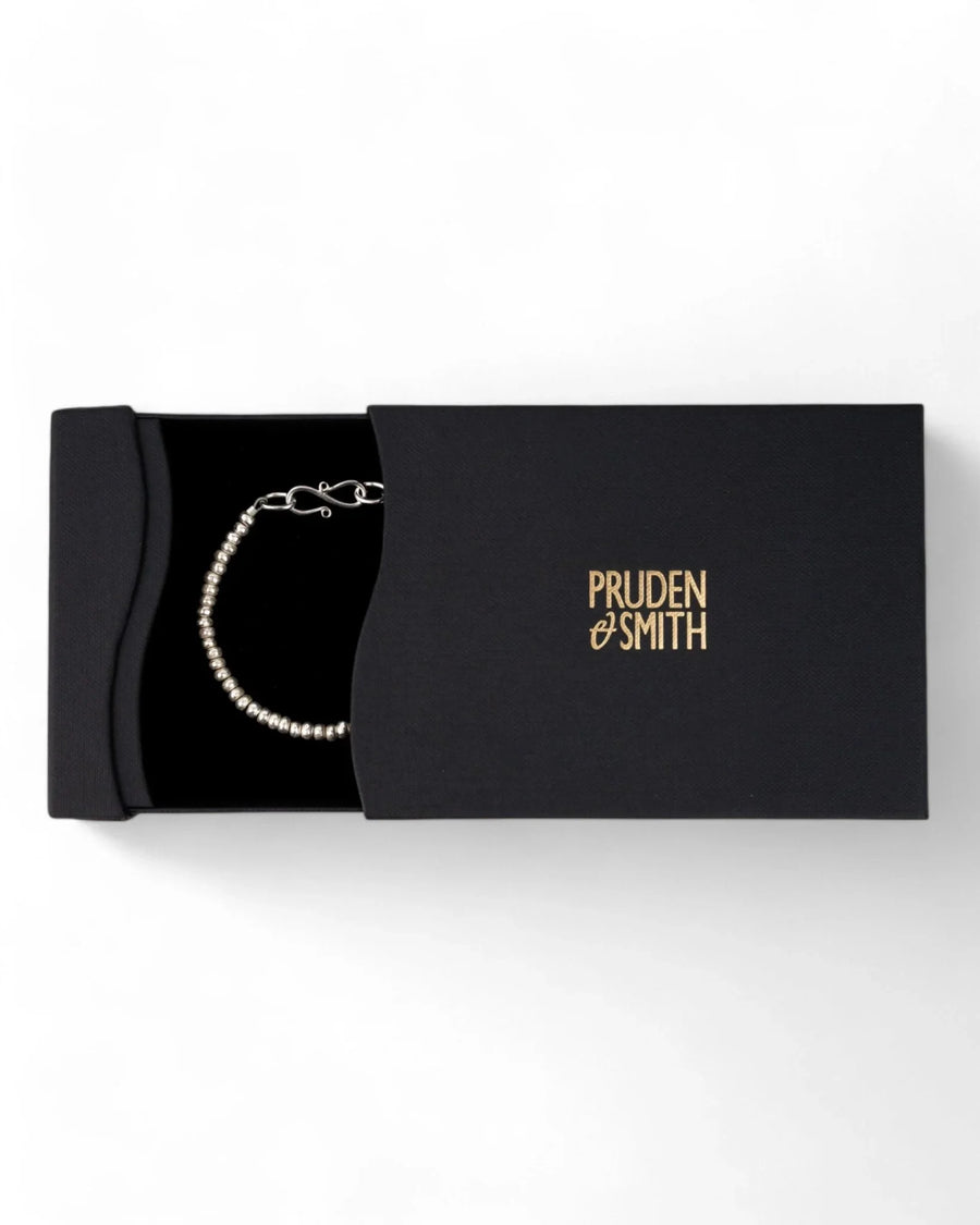 Handmade solid silver nugget bracelet in a black gift box on a white background