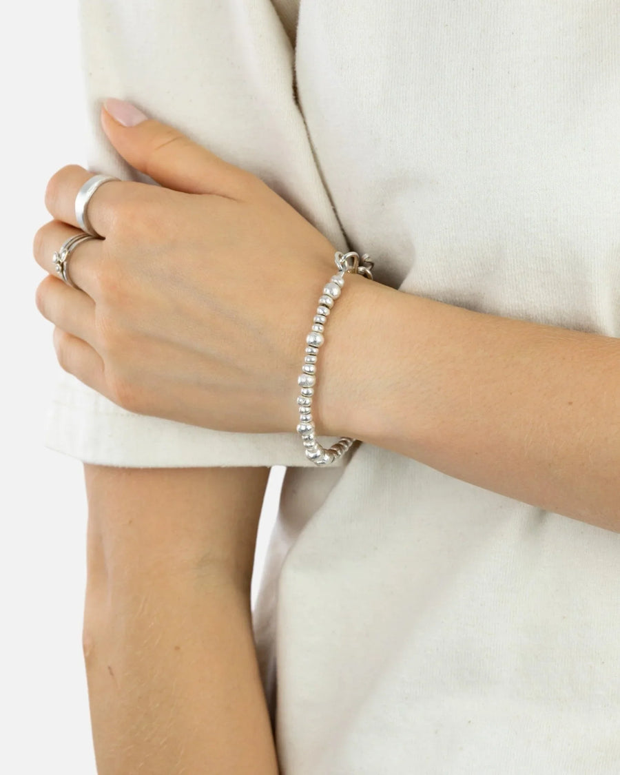 Handmade silver nugget bracelet with organic beads on wrist, casual style.