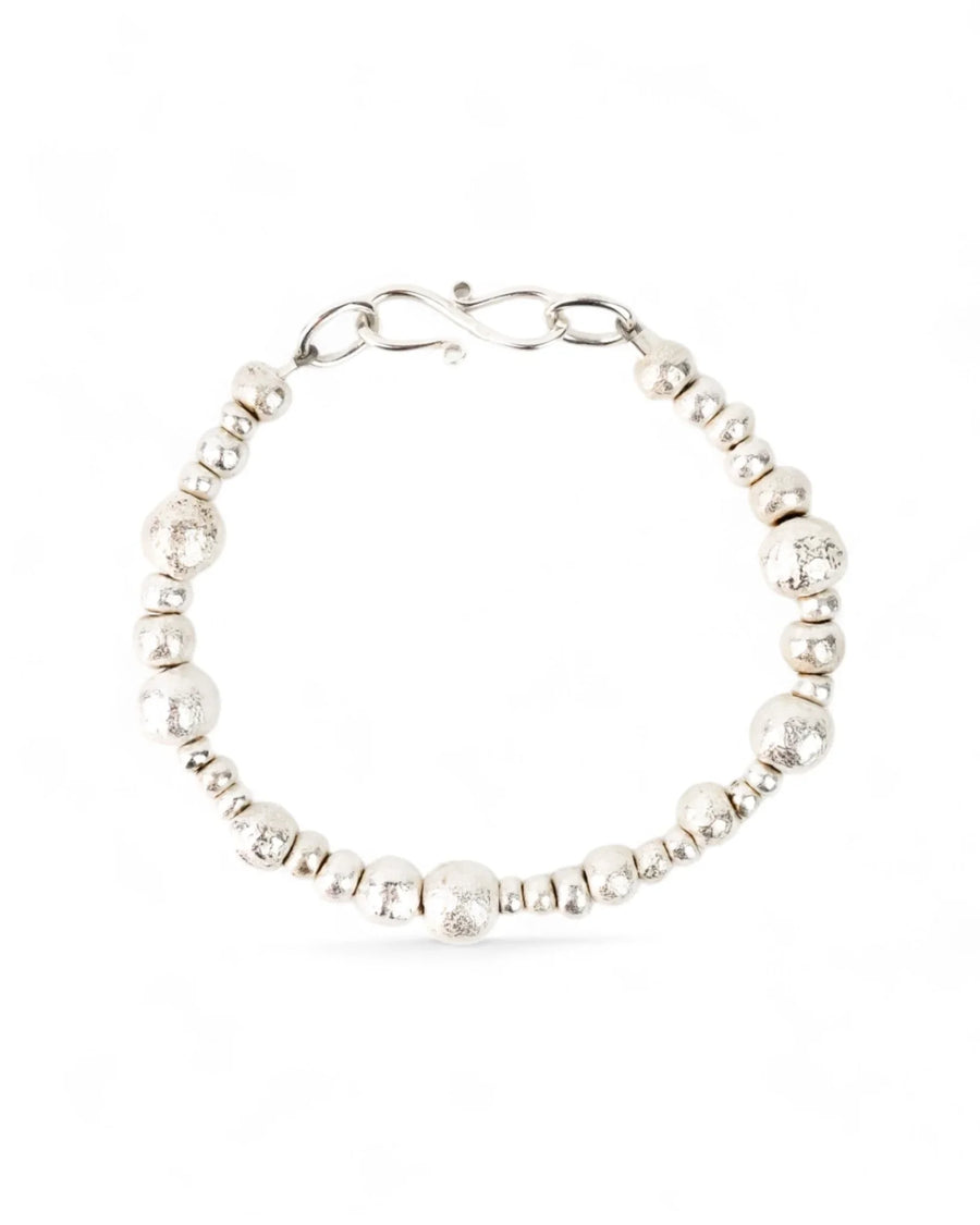 Handmade silver nugget bracelet with organic beads and textured finish on white background