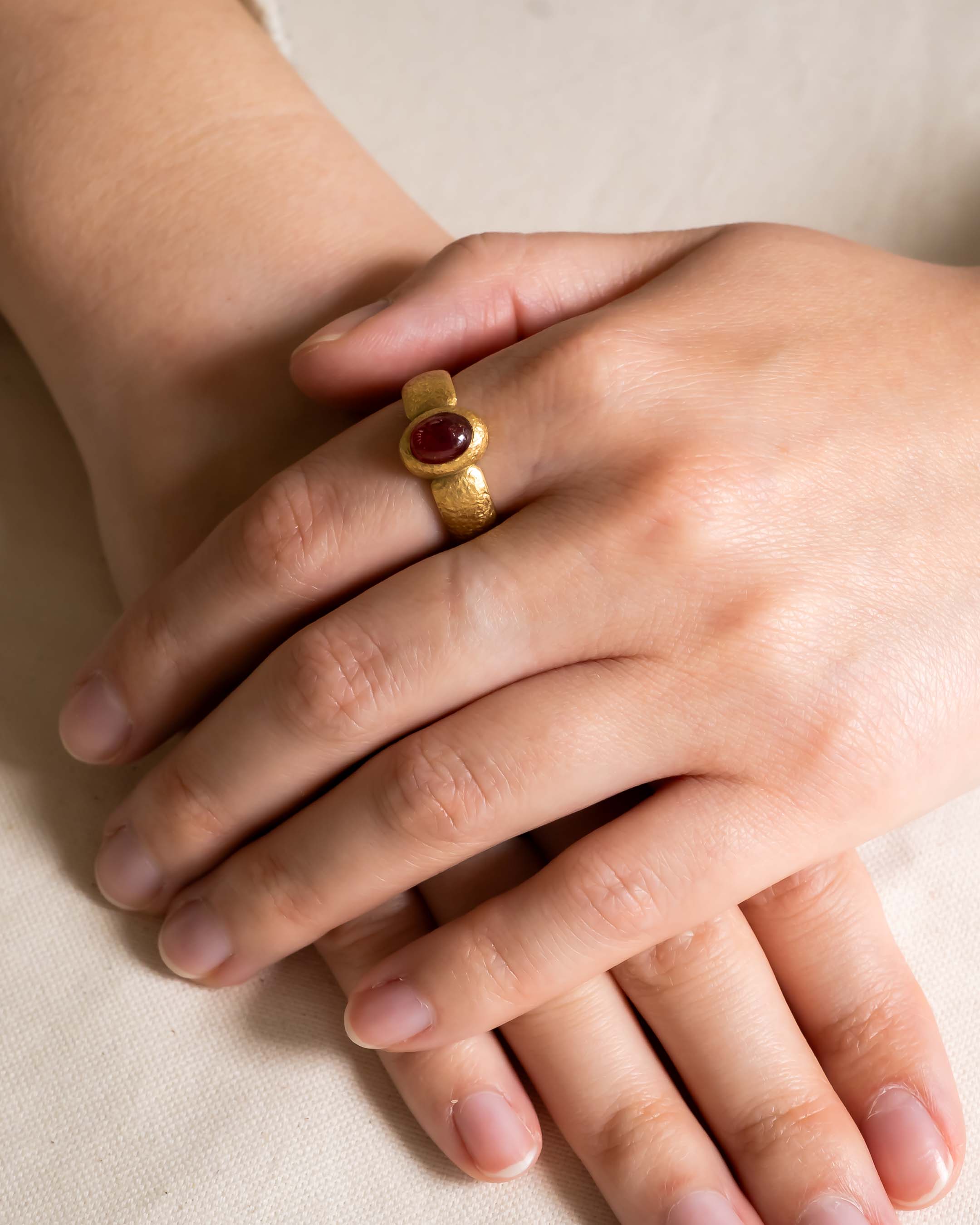 Nugget ruby and yellow gold ring on a hand.