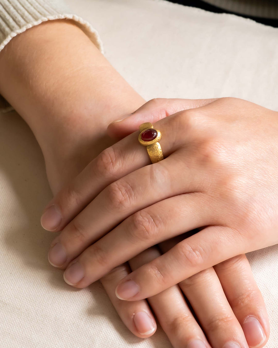 Nugget ruby and yellow gold ring on a hand.