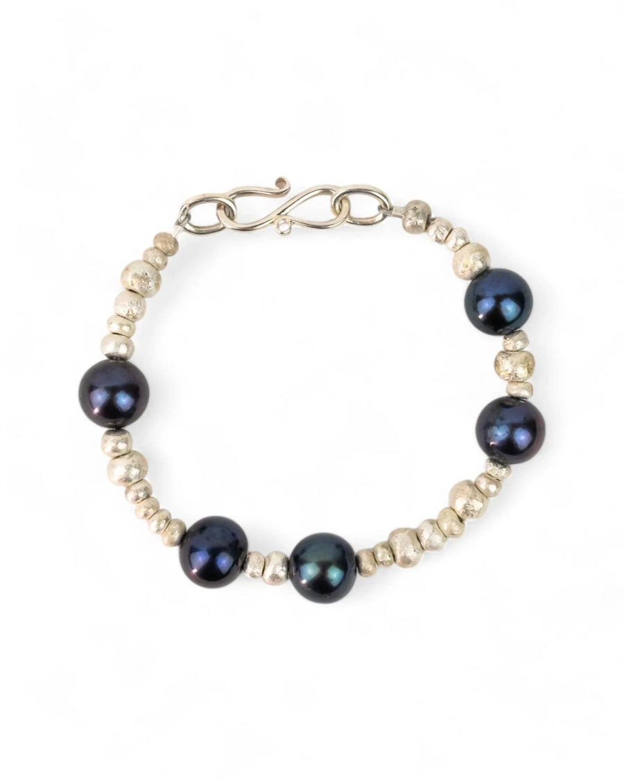 Silver nugget bracelet with black oil pearls and organic textured beads on a white background
