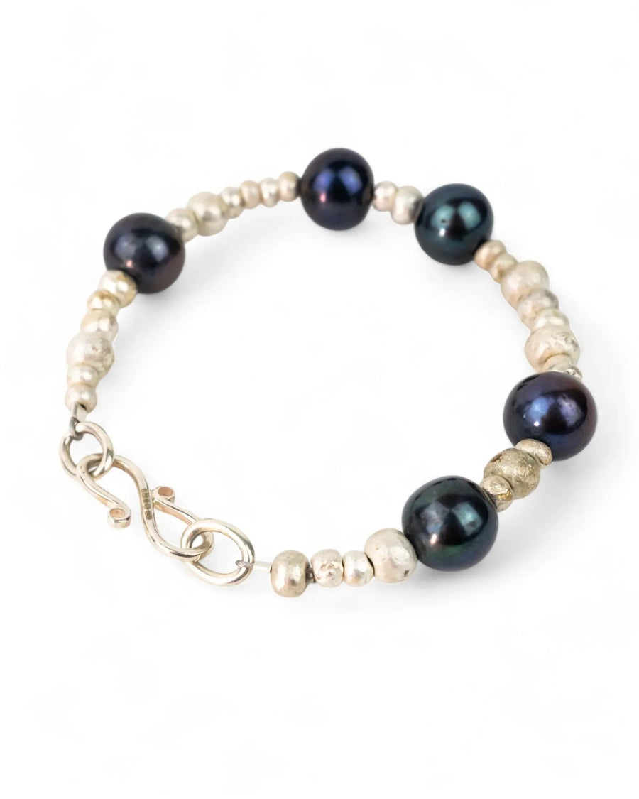 Silver nugget bracelet with black and oil pearl beads on white background