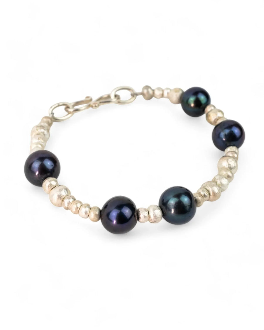 Handmade bracelet with silver nugget beads and black oil pearls on white background
