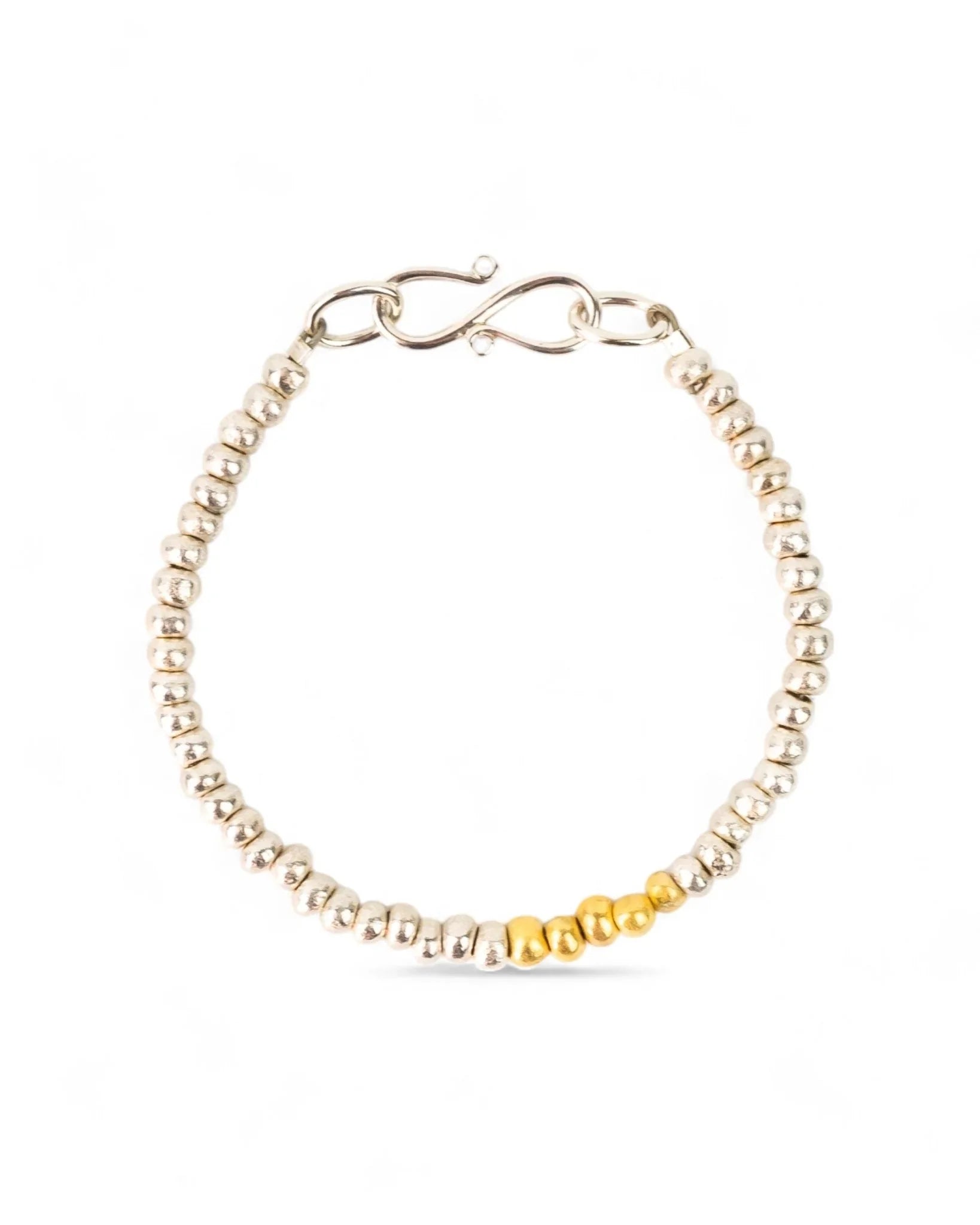 Beaded silver bracelet with gold accent section and handmade clasp on white background
