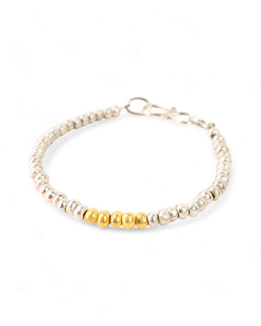 Handmade silver bead bracelet with a gold accent section on a white background