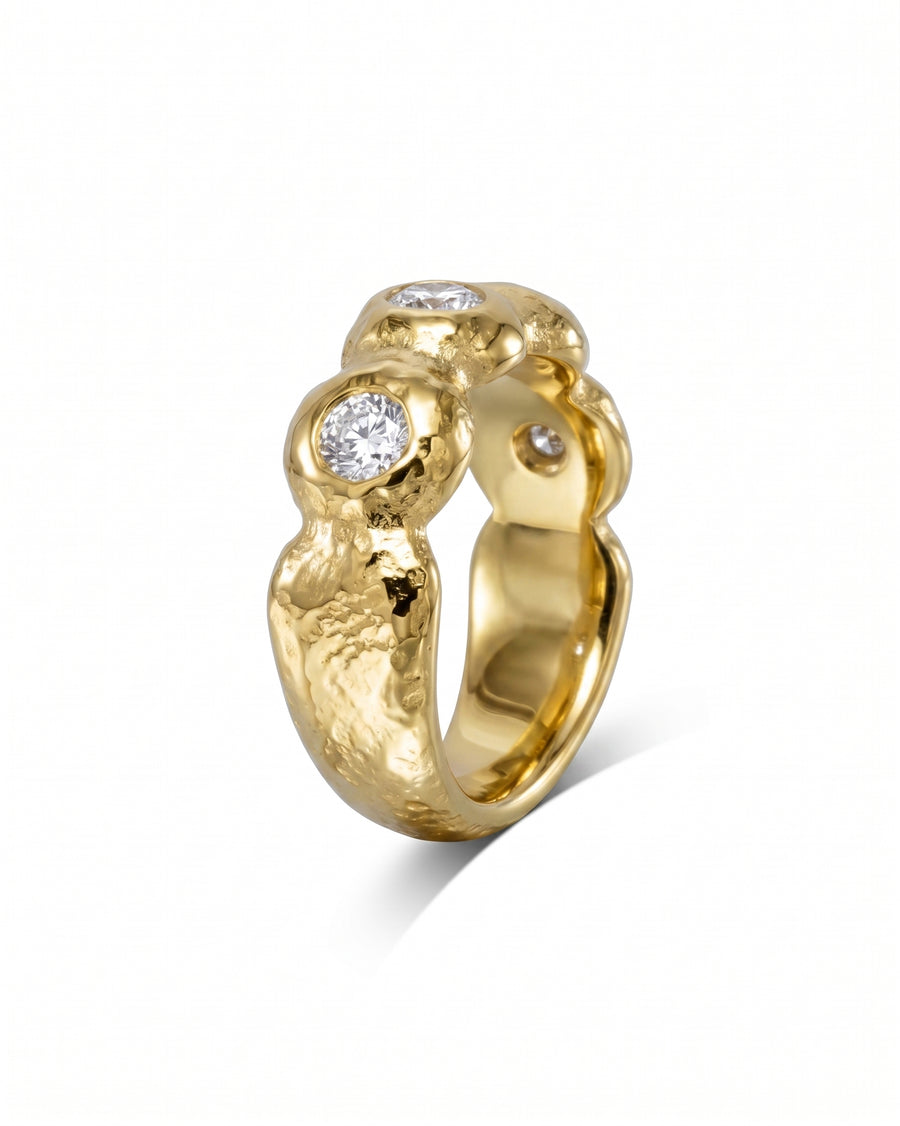 Nugget yellow gold diamond eternity ring with a textured band and three prominent diamonds.