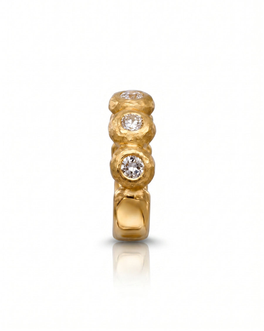 Nugget yellow gold eternity ring with three round diamonds.