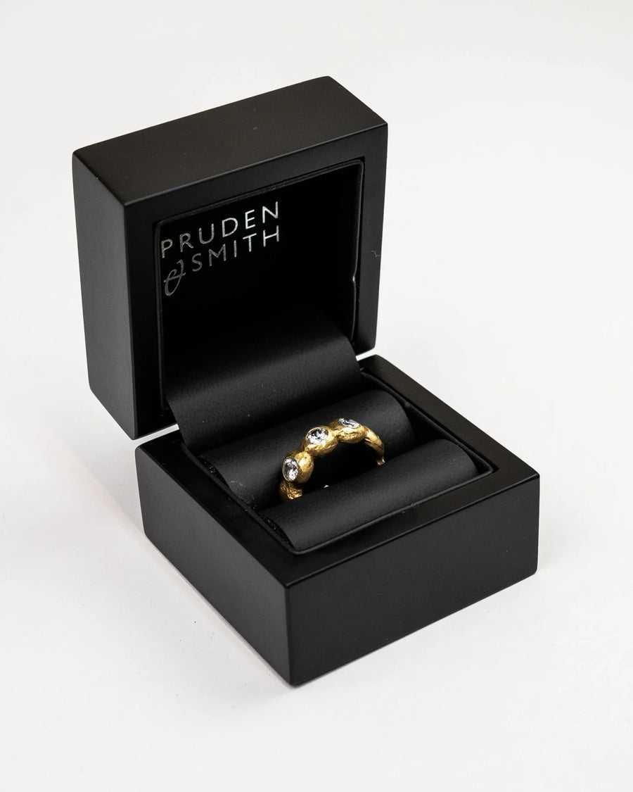 Nugget yellow gold diamond eternity ring in a black box.