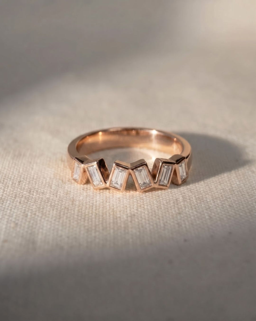 Rose gold half eternity ring with offset baguette diamonds.