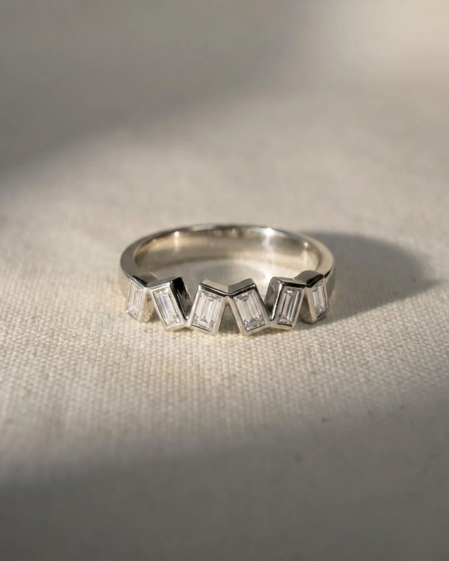 Platinum half eternity ring with offset baguette diamonds.