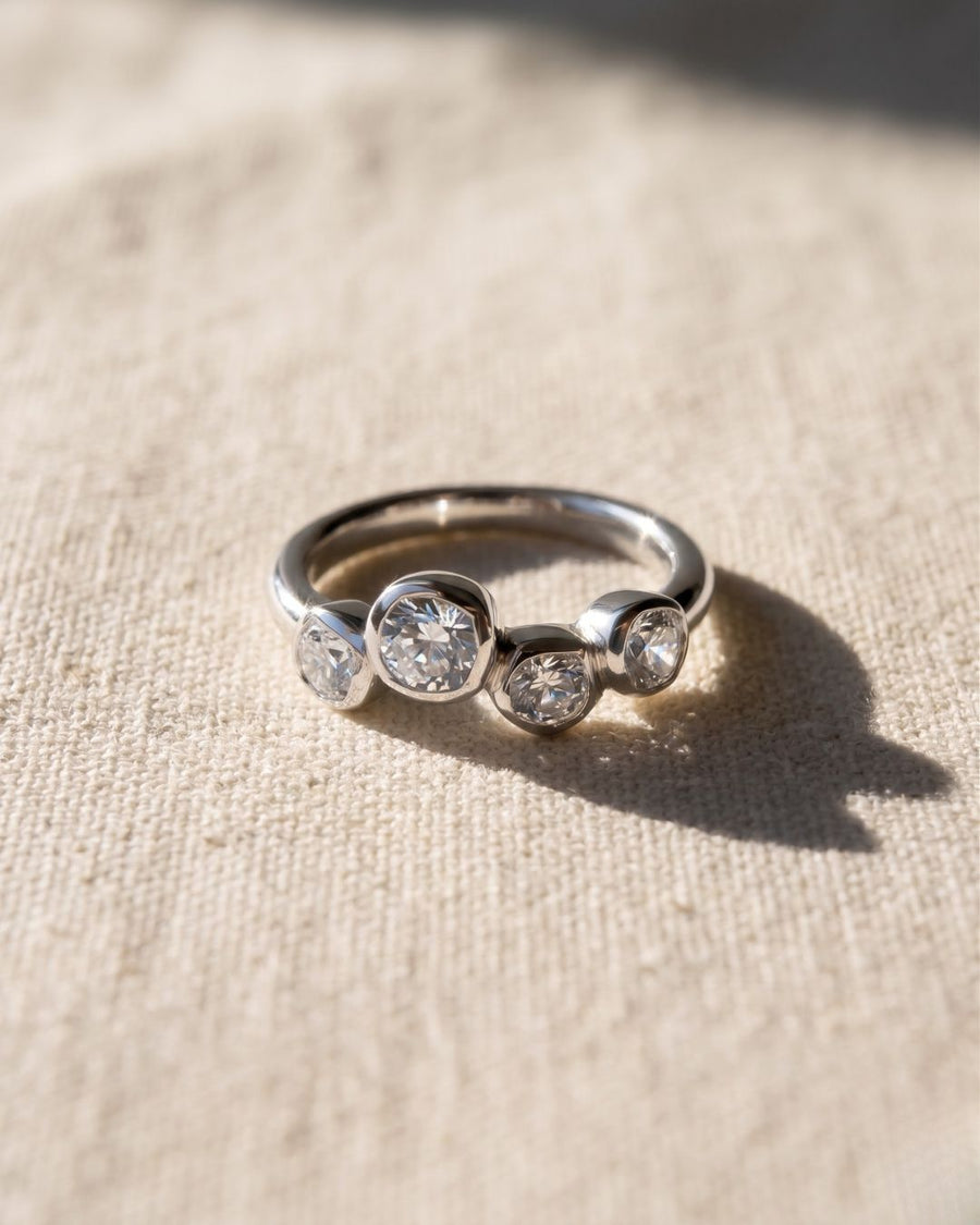 Platinum engagement ring with four offset old cut diamonds.