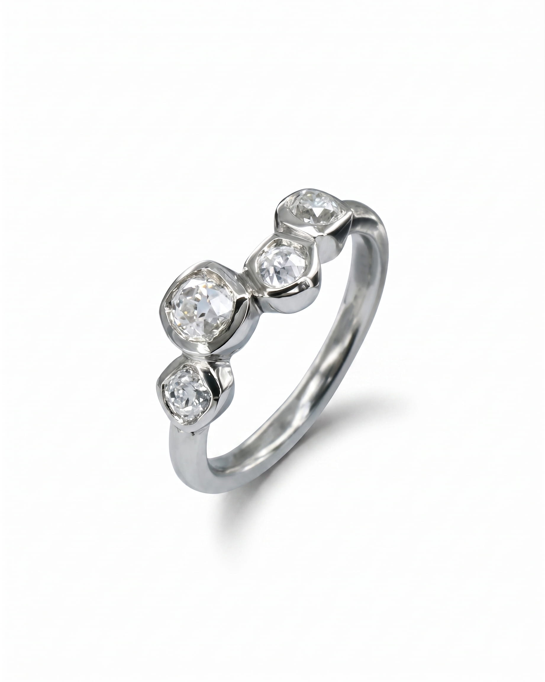 Platinum engagement ring with four offset old cut diamonds.