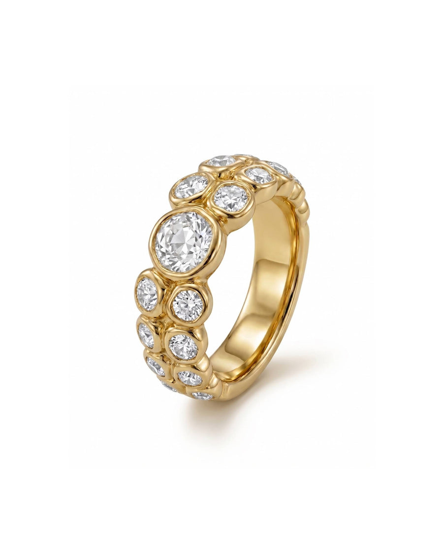 Gold eternity ring with bezel-set old cut diamonds in varying sizes.