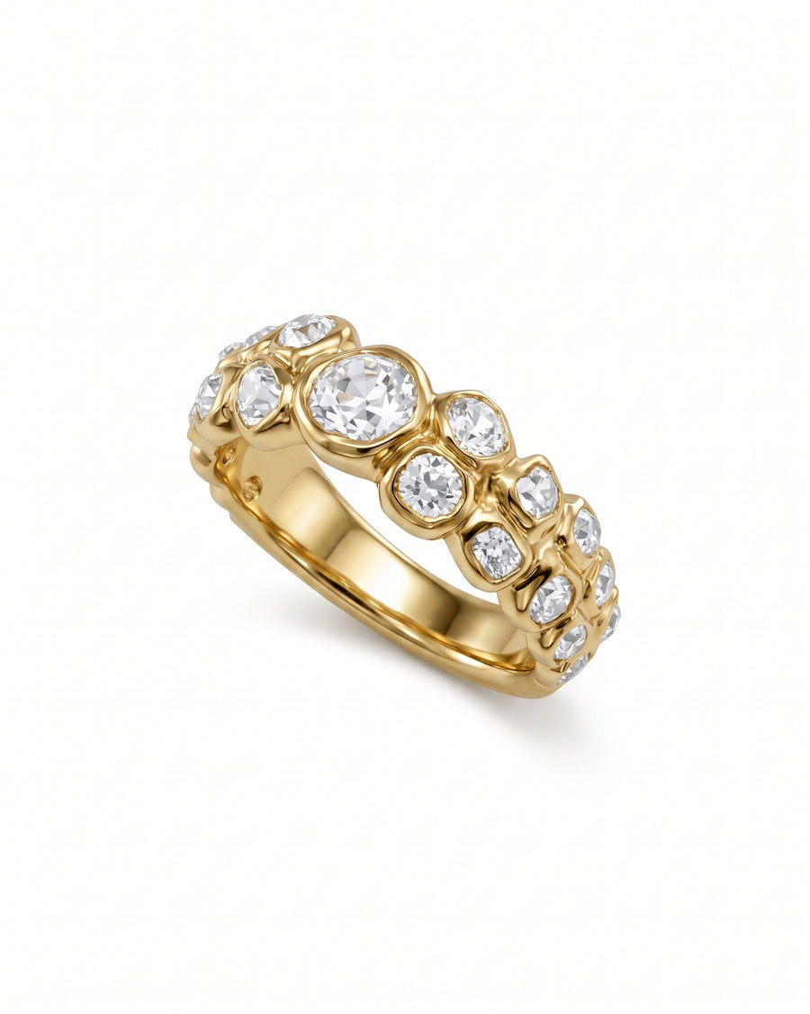 Yellow gold eternity ring with old cut diamonds in varied sizes.