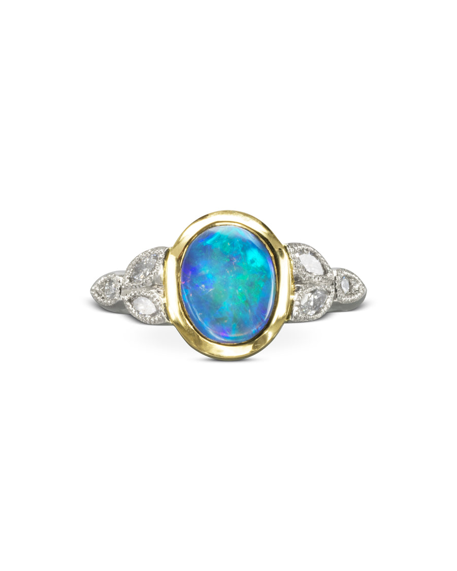 Gold and silver ring with an oval blue opal and diamond accents.