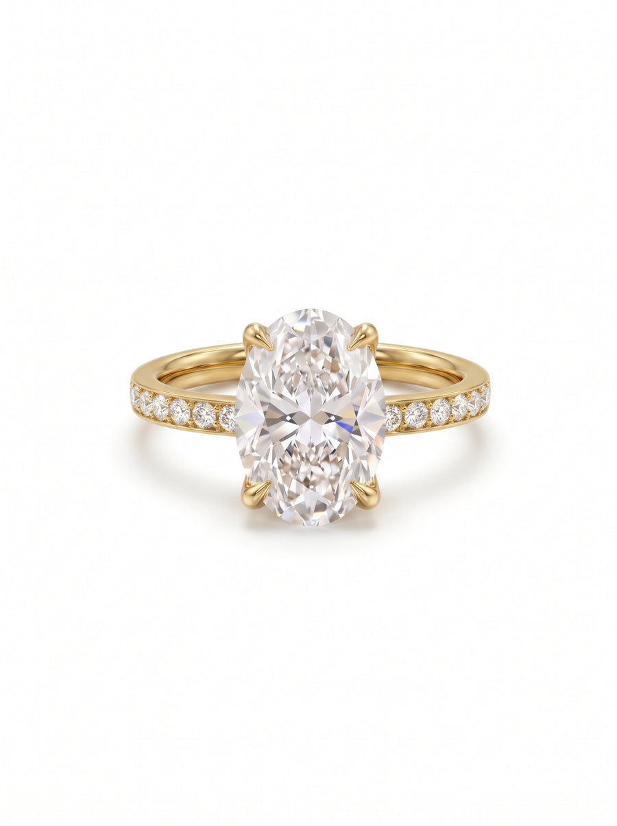 Oval diamond solitaire engagement ring in 18ct yellow gold with a pavé diamond band.