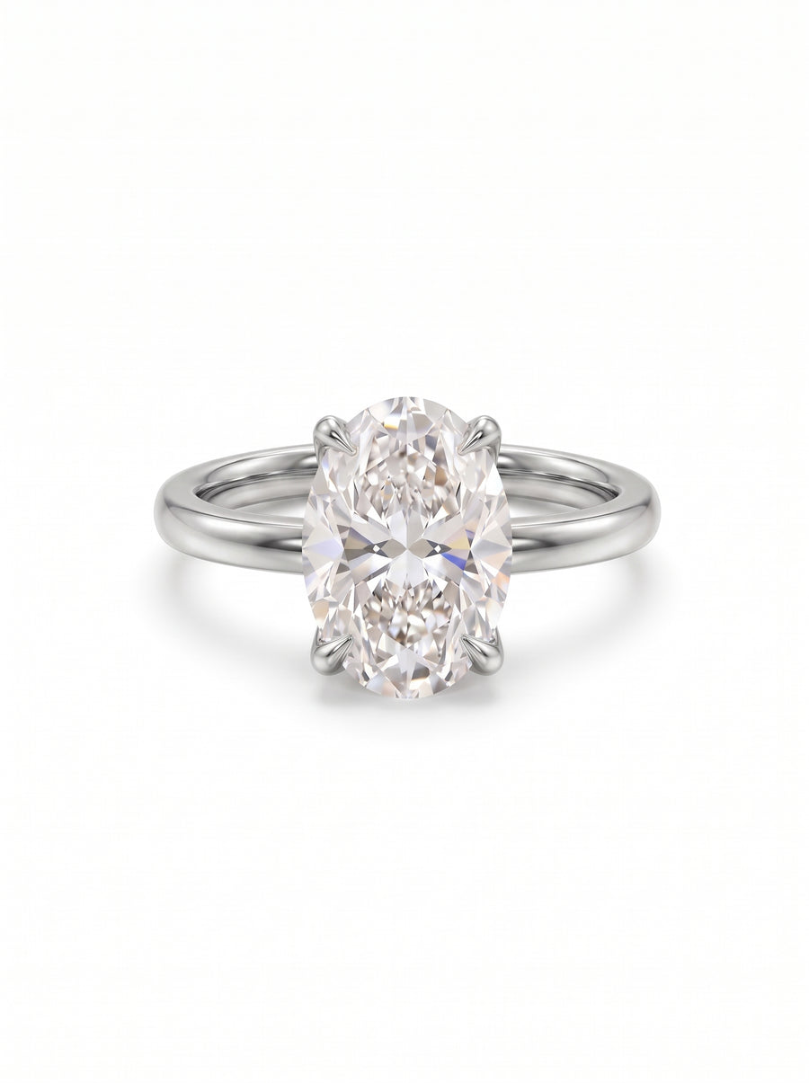 Oval cut diamond solitaire engagement ring set in a polished silver band with four prongs.
