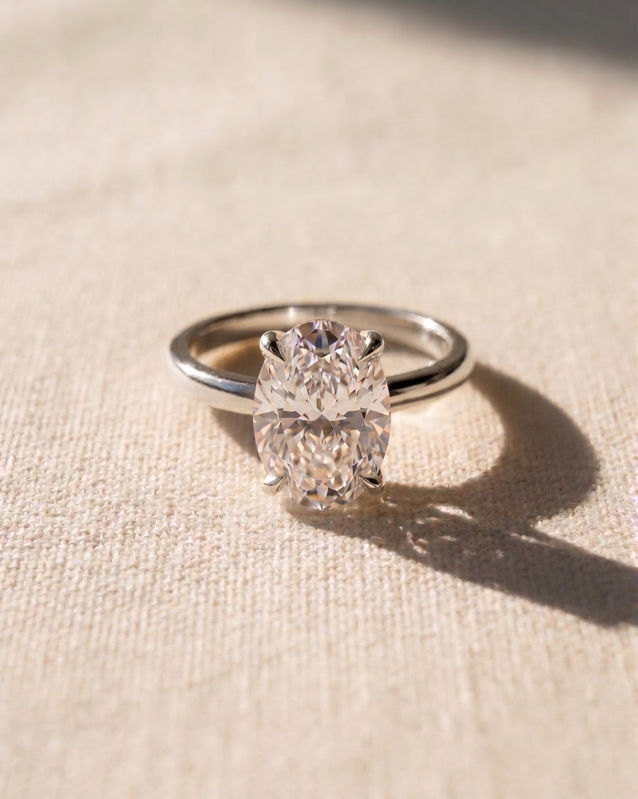 Platinum solitaire engagement ring with an oval diamond.