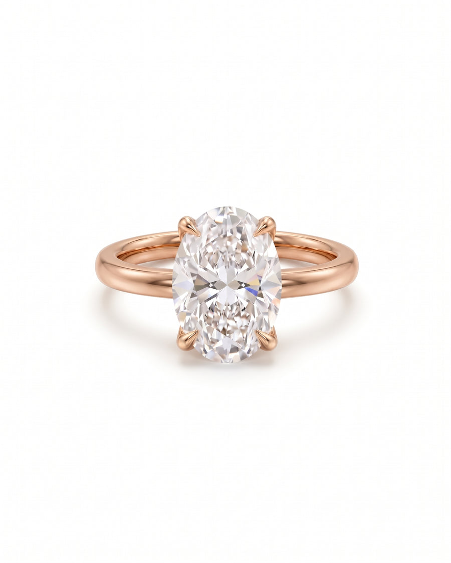 Oval solitaire engagement ring with a diamond set in a rose gold band on a white background.