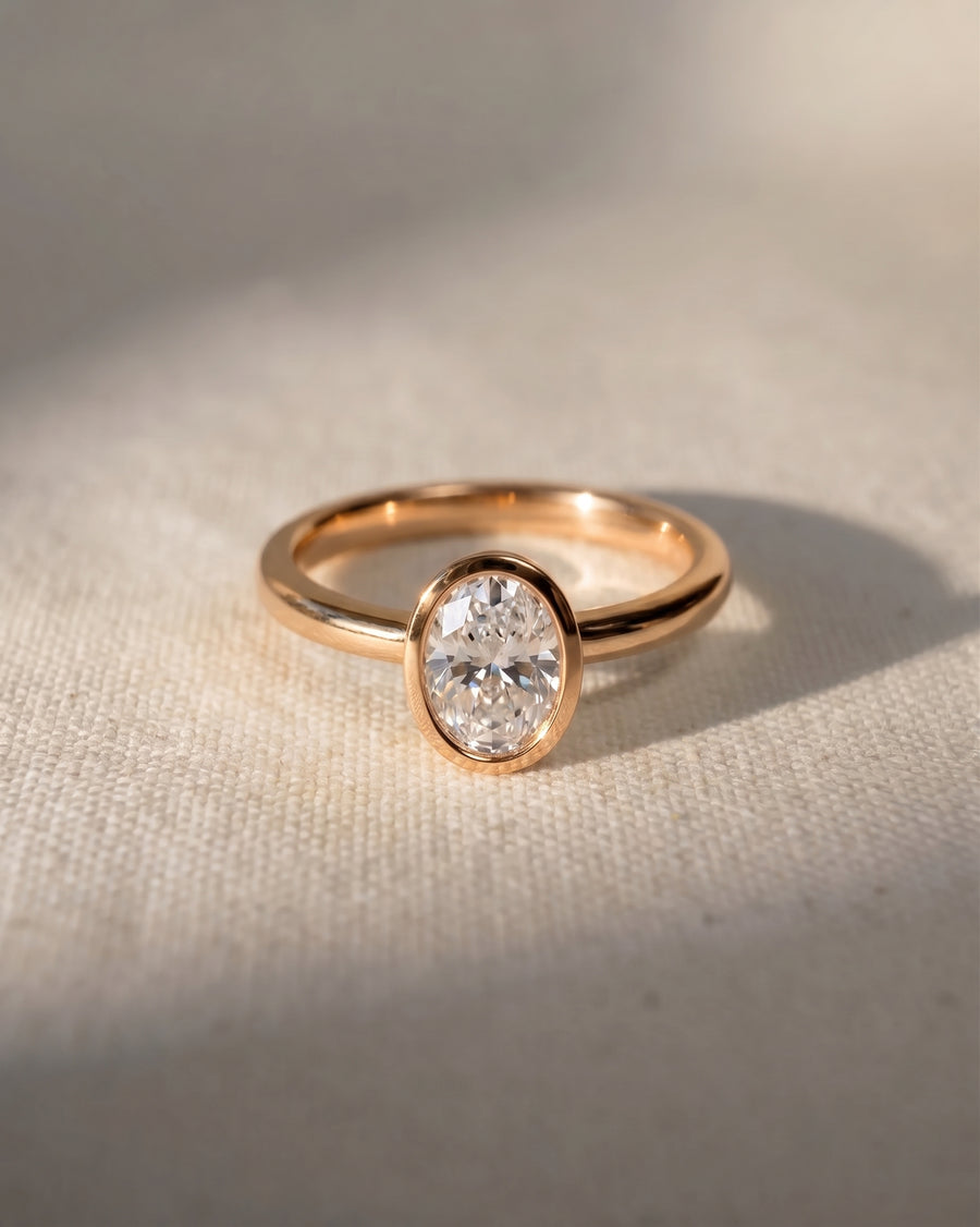 Rose gold engagement ring with a 1ct oval lab-grown diamond in a bezel setting.
