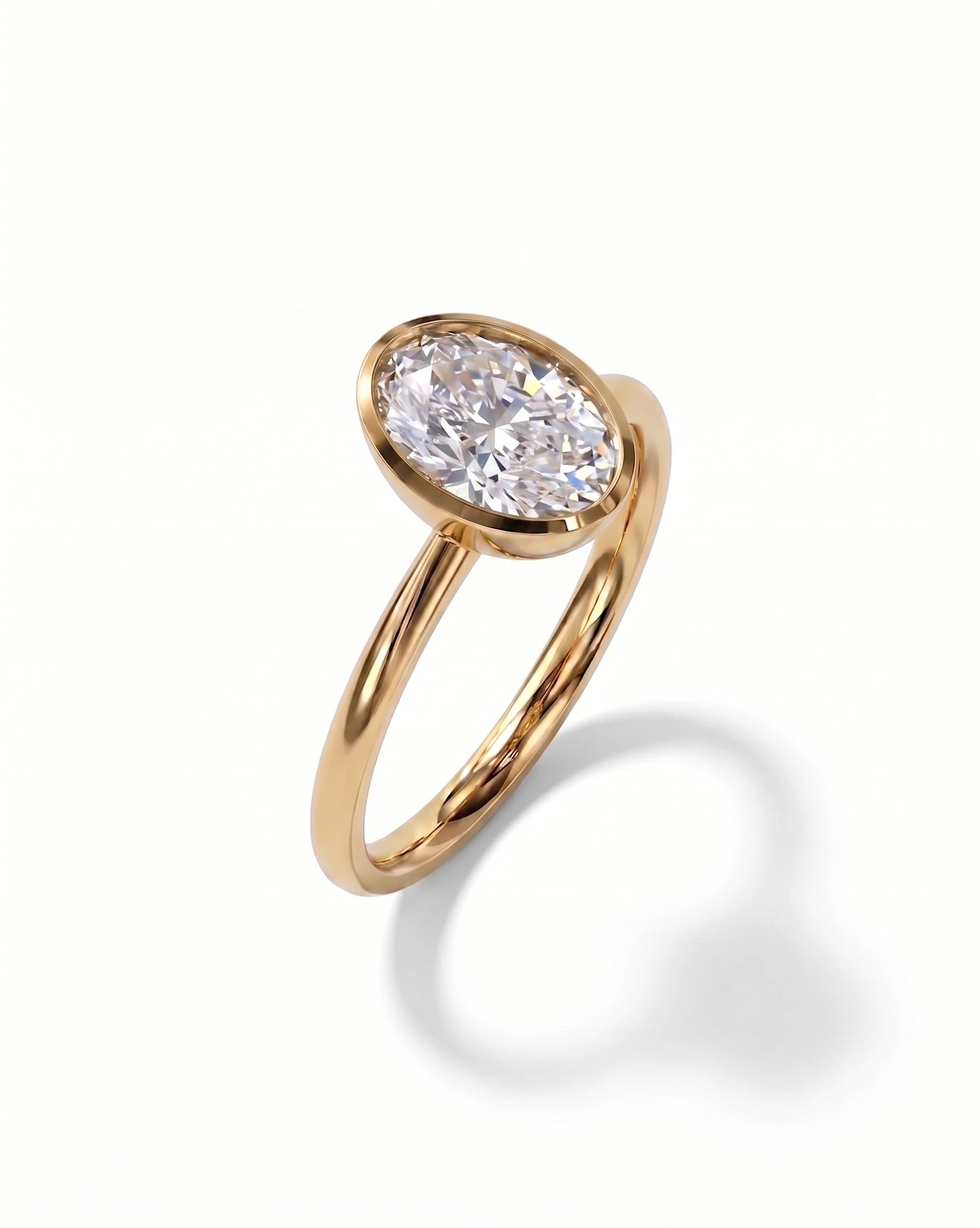 Gold ring with an oval cut diamond in a bezel setting.