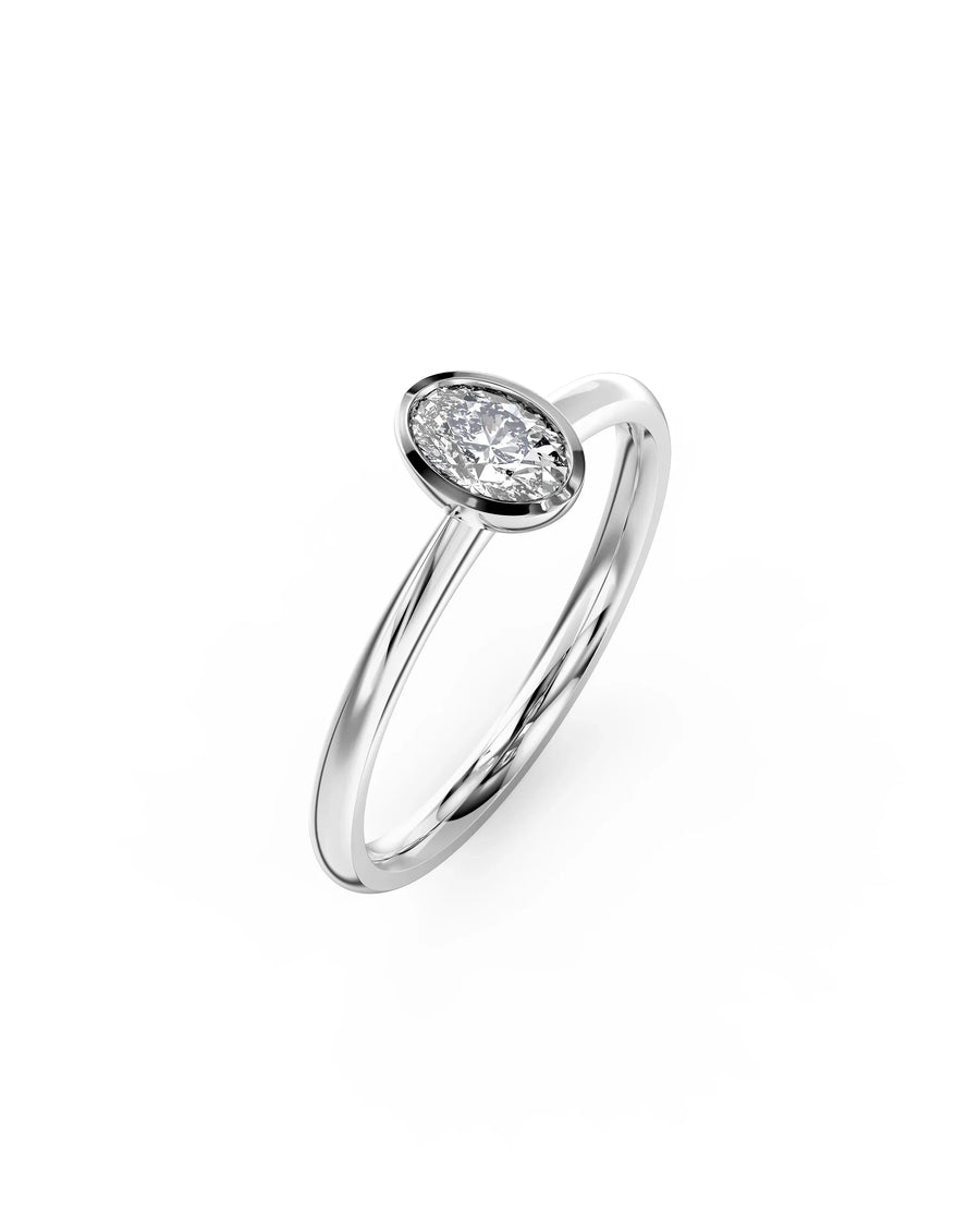 Silver ring with an oval cut diamond in a bezel setting.