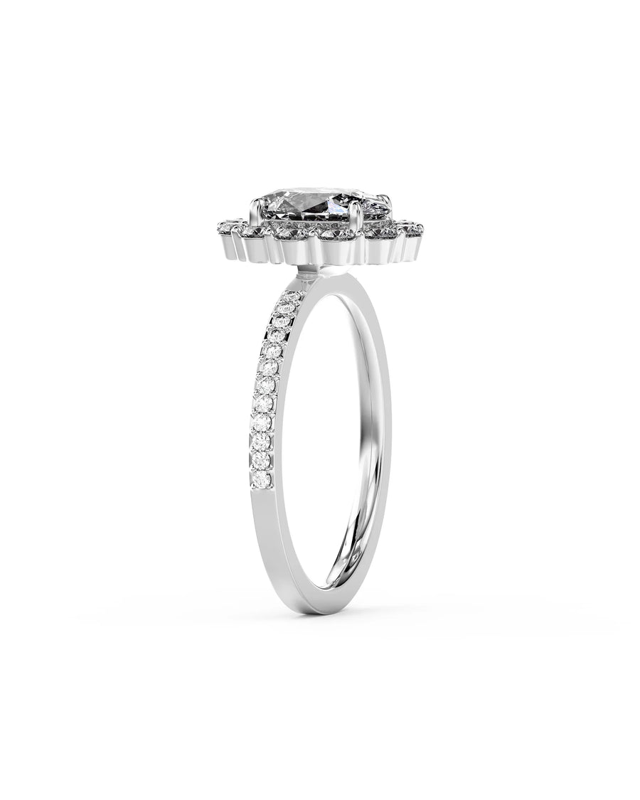 Oval cut diamond ring in platinum with a claw set halo and pavé diamond band.