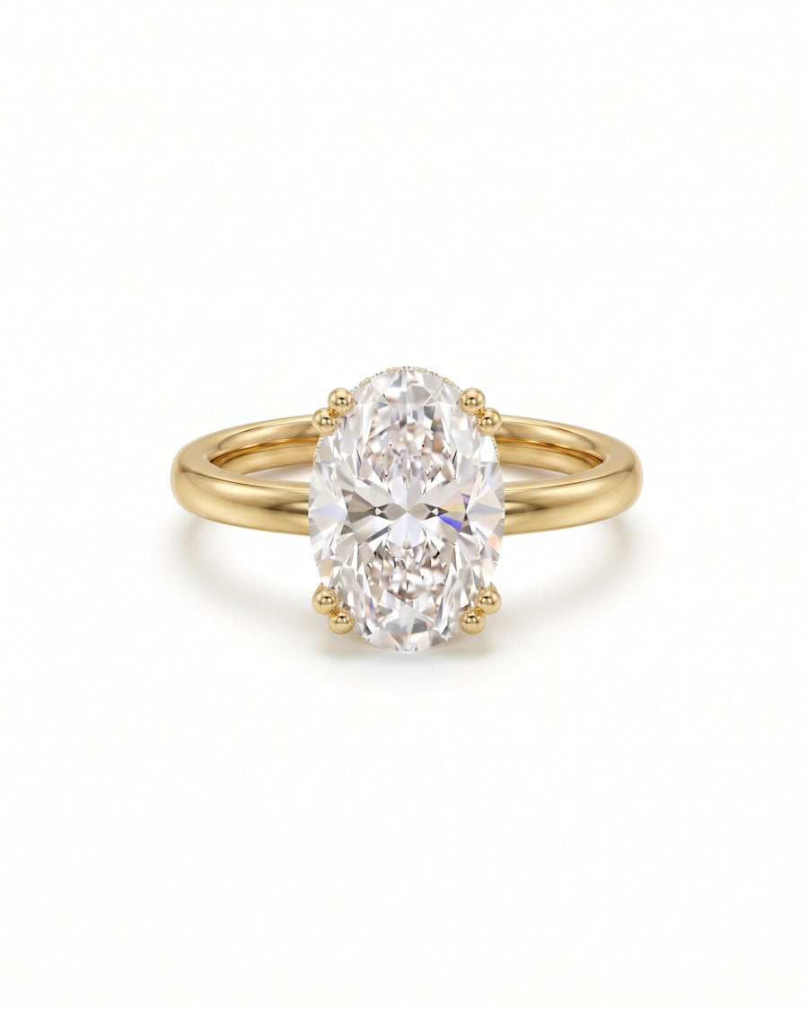 Oval cut diamond engagement ring with a hidden halo on a polished yellow gold band.