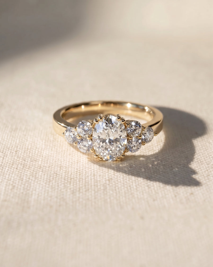 18ct yellow gold oval cut trefoil claw engagement ring with diamonds.