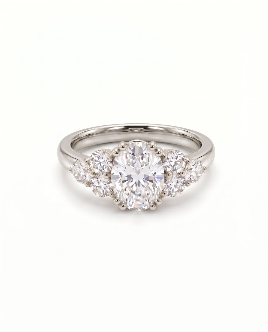 Oval cut diamond engagement ring with trefoil claw settings on a polished platinum band.
