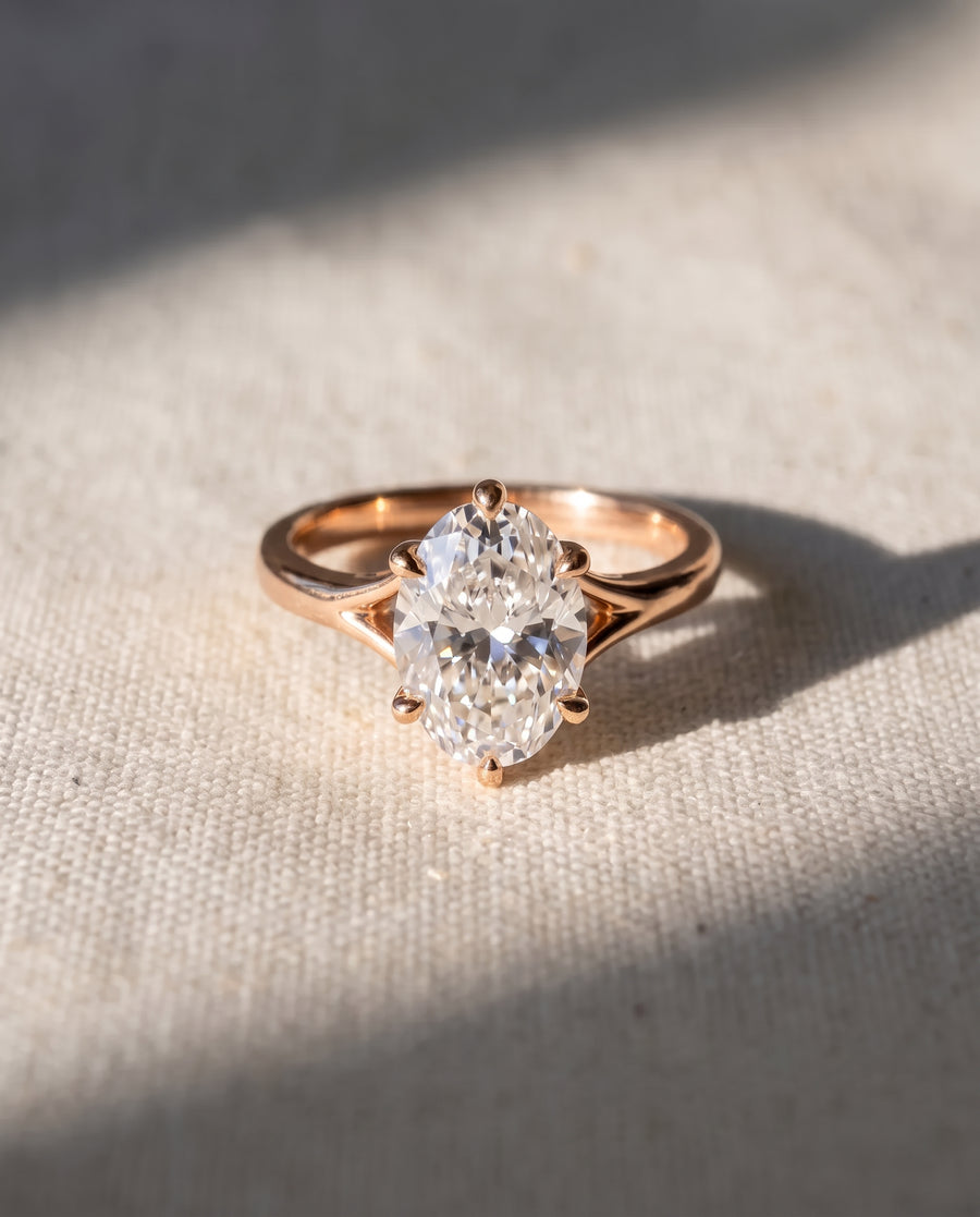 Oval cut diamond engagement ring with a tulip claw setting on a rose gold band.