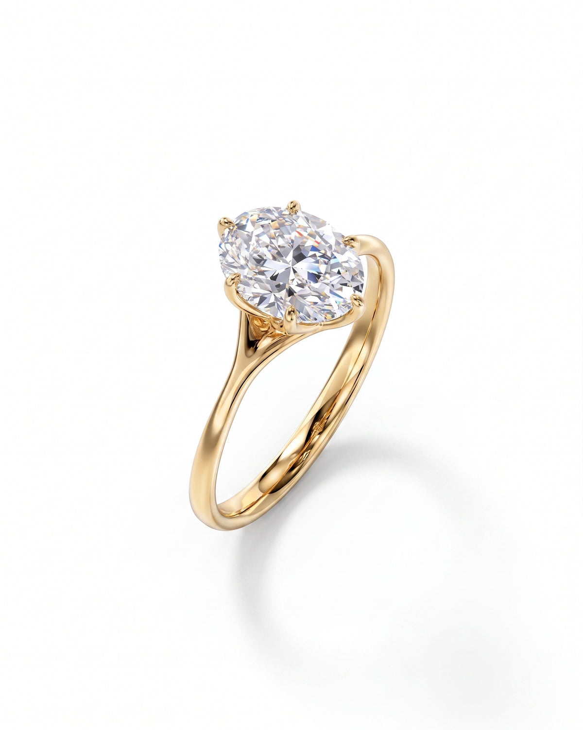 Oval cut diamond engagement ring in a yellow gold tulip claw setting on a white background.