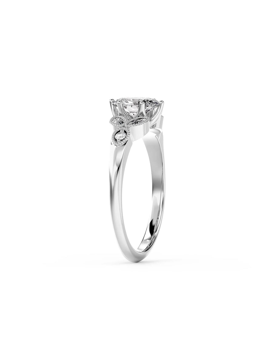 Oval cut diamond engagement ring in silver with vintage-style floral side accents and small round diamonds.