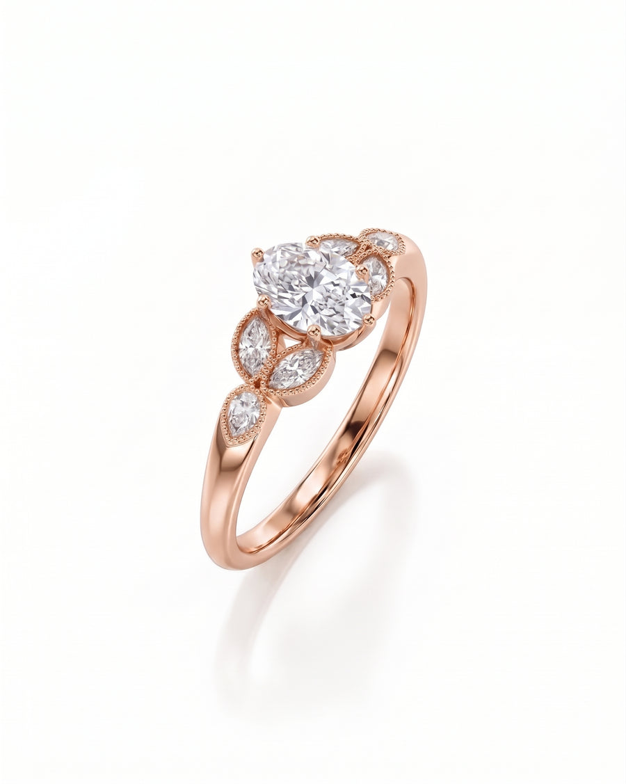 Oval cut diamond engagement ring in rose gold with marquise side stones and milgrain detailing.